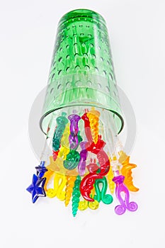 Colorful plastic swizzle sticks spilled from glass on white back