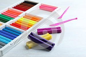 Colorful plasticine and tools on white table