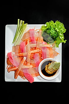 A colorful platter of sashimi sushi with tuna and crab sticks