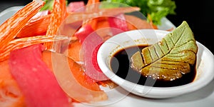 A colorful platter of sashimi sushi with tuna and crab sticks