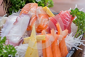 A colorful platter of sashimi sushi with tuna and crab sticks