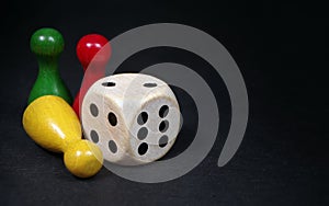 Colorful play figures with dice on black board. copy space