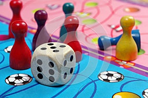 Colorful play figures with dice on black board. copy space