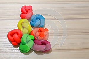 Colorful playdough close up image on wooden table.