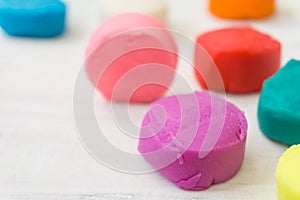 Colorful playdough on wooden table.