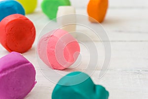 Colorful playdough on wooden table.