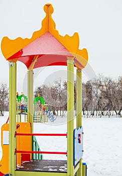 Colorful Playground in the form of a house or gazebo in the amusement Park, winter, snow, vertical frame