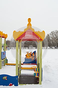 Colorful Playground in the form of a house or gazebo in the amusement Park, winter, snow, vertical frame