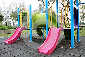 Colorful playground in public park, slide and swing on yard activities for children.