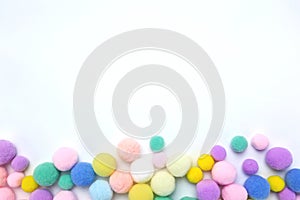 Colorful pom poms on white copy space background