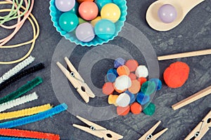 Colorful pompoms, balls and rubber erasers using for playing and development of kids motor skills, coordination and logical