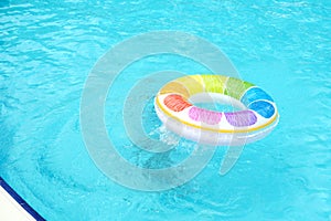 A colorful pool float bobs in tranquil water, capturing a serene summer vibe. This scene reflects leisure and the joy of