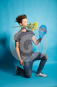 Colorful portrait of young funny man posing on blue wall