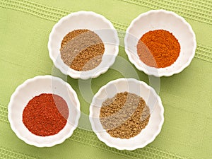 Colorful powdered spices in white bowls