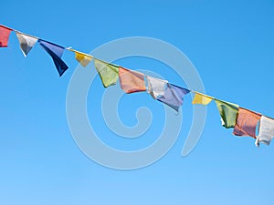 Colorful prayer flags over a clear blue sky in India