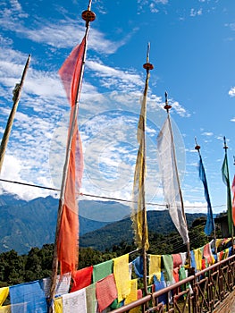 Colorful prayer flags over a clear blue sky near a temple in Bhutan