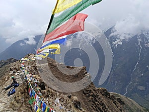 Colorful prayer flags waving against a cloudy sky in mountains