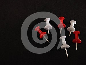 Colorful push pin on black background