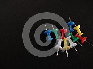 Colorful push pin on black background