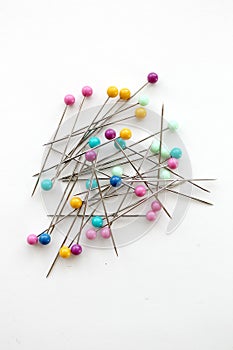 Colorful push pins for sewing on a white background