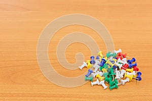 Colorful push pins on wooden background. with copy space