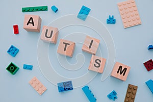 Colorful puzzle and wooden blocks with AUTISM word. Top view