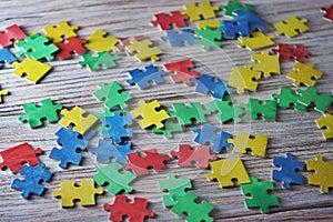 Colorful puzzles on a white wooden background, frame, concept of early childhood autism