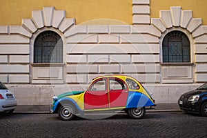 Rome, Italy: Colorful and quirky customized Volkswagen Beetle parked on the side of a cobblestone street.