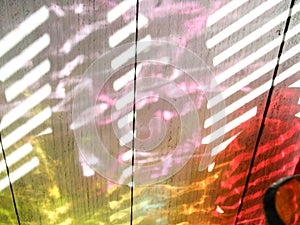 Colorful rainbow bottles reflections, against window shades