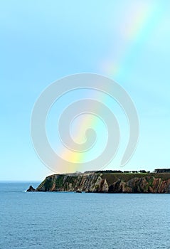 Colorful rainbow over sea coast.