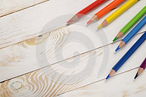 Colorful rainbow pencil on white wood plank background