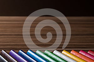 Colorful rainbow pencils on the brown table background