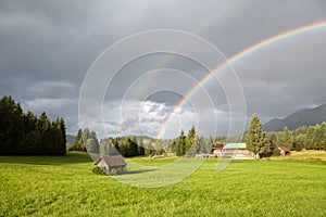 Colorful rainbow during rain in Alps