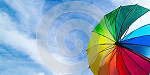Colorful rainbow umbrella on blue sky background. LGBT, Pride Month, diversity, Sunprotect Concept