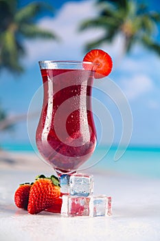 Colorful red cold drink on a beach, summer background