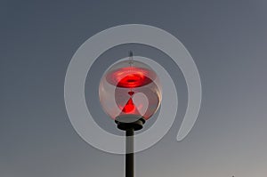 Colorful red gas glass street lamp against blue sky on the background