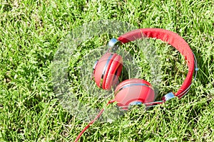 Colorful red headphones on sunlight glade