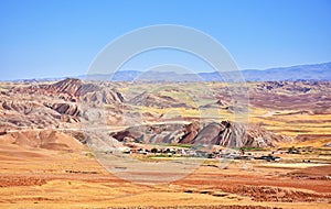 Colorful red mountains and a village