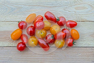 Colorful red, orange and yellow cherry tomatoes on wooden background