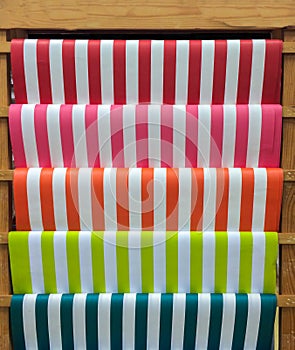 Colorful Red, Pink, Orange, Green and Blue Stripe Pattern Paper on Wooden Shelf for DIY Work