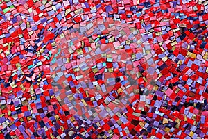 Colorful red, pink, yellow, and purple stone mosaic tiles on the wall