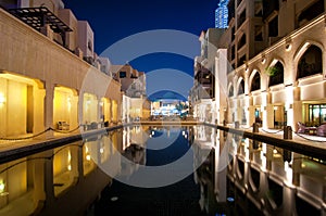 Colorful reflection of souk building in Downtown area during calm night. Dubai, United Arab Emirates.