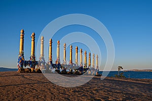 Colorful ribbons on the wooden pillars in sacred buryat place on cape Burkhan in Khuzhir village in Olkhon island, lake