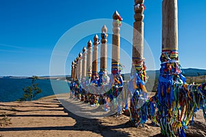 Colorful ribbons on the wooden pillars in sacred buryat place on cape Burkhan in Khuzhir village in Olkhon island, lake