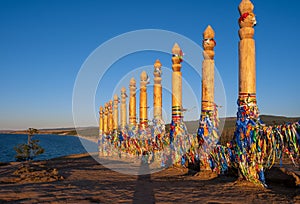 Colorful ribbons on the wooden pillars in sacred buryat place on cape Burkhan in Khuzhir village in Olkhon island, lake