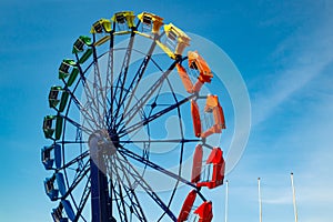 Colorful ride in motion in amusement park on sky background