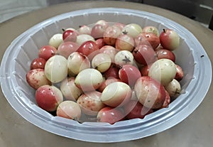 Colorful ripe carissa carandas fruit on a plate