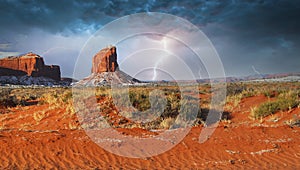 Colorful rock formations with a dusting of snow in the Navajo Nation Park Monument Valley during a lightening storm