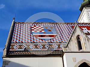 Colorful roof detail of the St Mark`s church in Zagreb, Croatia. blue sky.