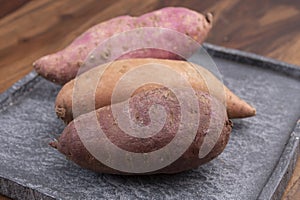 Colorful root vegetables pink, purple and orange organic sweet potatos